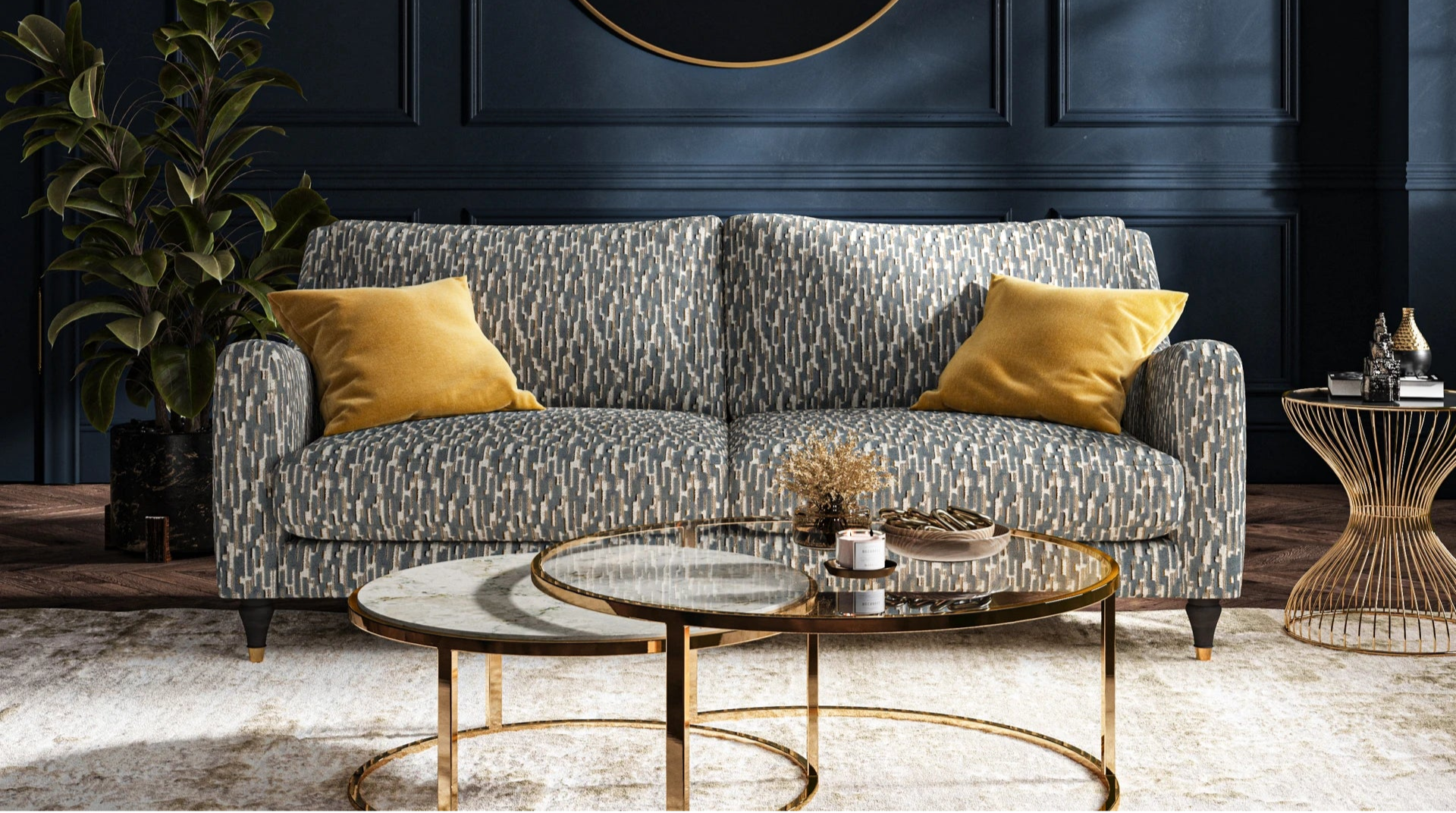Living room with a gray sofa, gold coffee table, and decorative mirror on a dark blue wall.